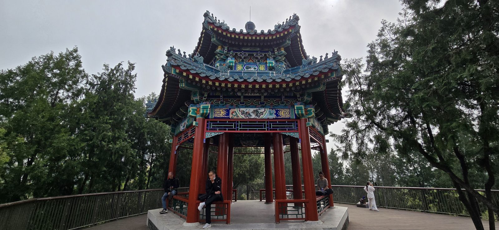 A painted pavilion through the trees in Dongdan Park
