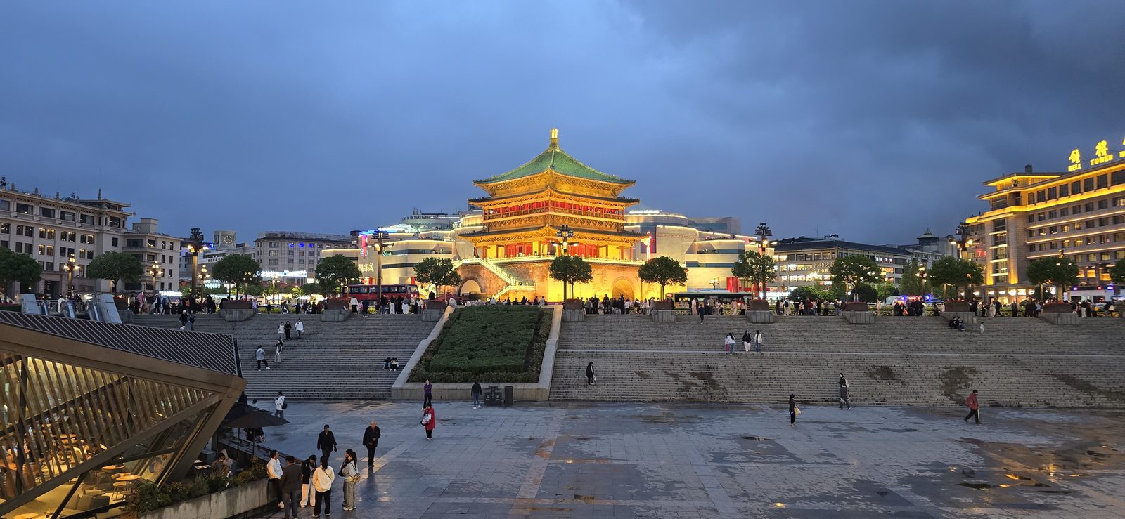 The Bell Tower lit up beyond the wet plaza in Xi'an