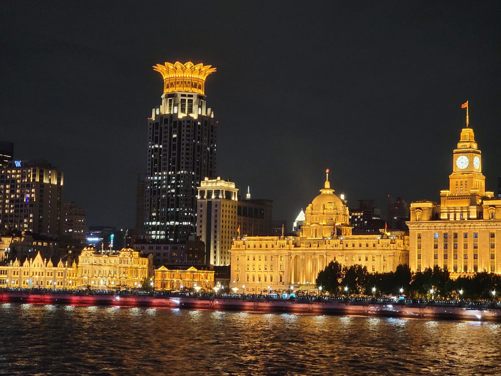 The Bund lit up gold from the river