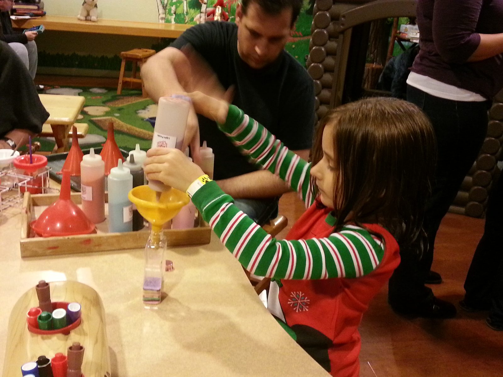 Lisa mixing colored sand with some help